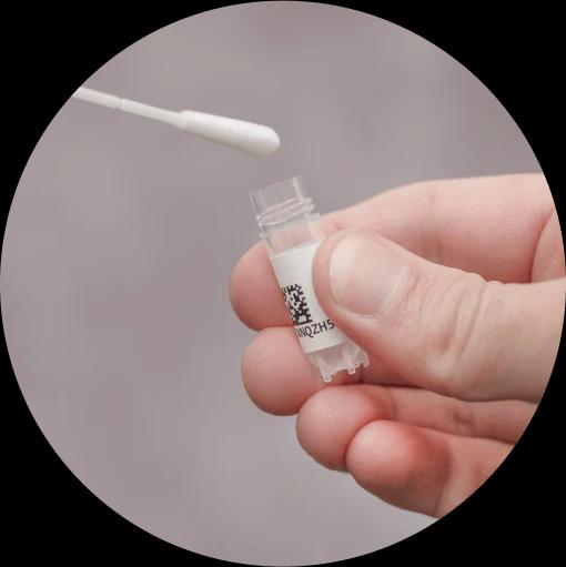 Hand holding a whole genome sequencing vial while a sample is being inserted. 